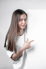 Naklejka premium Girl teenager demonstrating a blank sheet of paper shows a finger.