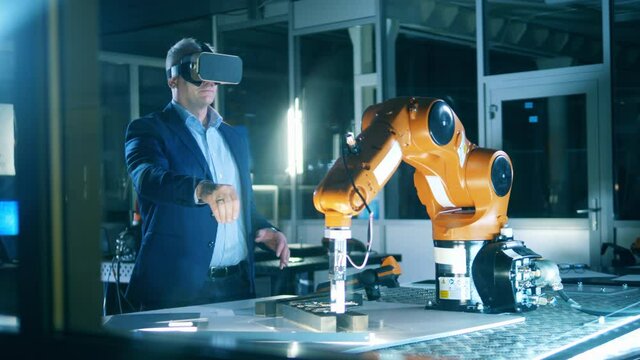 VR, futuristic, virtual reality concept. Engineer wearing VR headset testing robotics at laboratory