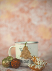 cup of coffee or tea with christmas tree toys on pink background