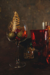 new year and christmas background with different glasses and toys for the christmas tree on a dark background