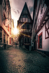 Fototapeta na wymiar Half-timbered house from Germany located in a street. Cloudy in the evening and illuminated