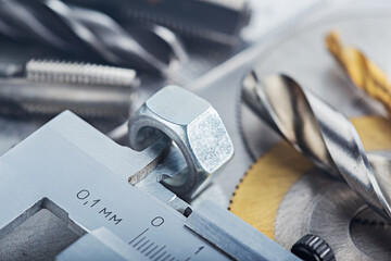 Measuring with vernier caliper nut for locksmithing work on steel plate. Locksmithing workshop.