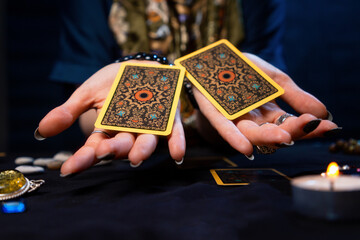 Cartomancy. The fortune teller holds out two Tarot cards on her palms. Close up. The concept of...