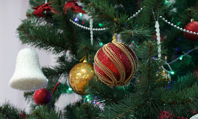 Decorative Christmas bauble and ribbons hanging from an artificial pine tree. Ushers in the spirit and joy of Christmas.