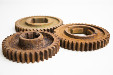Rusty gears from an old mechanism on a white background, photographed up close.