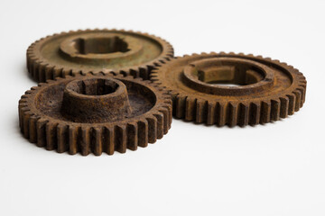 Rusty gears from an old mechanism on a white background, photographed up close.