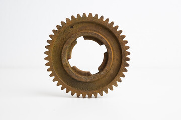 Rusty gear from an old mechanism on a white background, photographed up close.