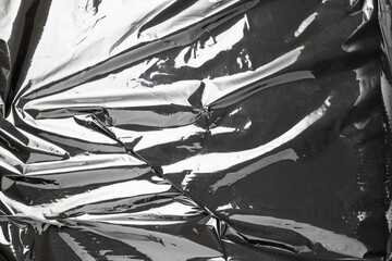 Smooth texture. Black shiny film bag pattern. Wrap transparent dark cellophane background. Real...