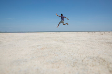 Fototapeta na wymiar person jumping on the beach