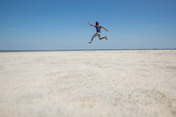 person jumping on the beach