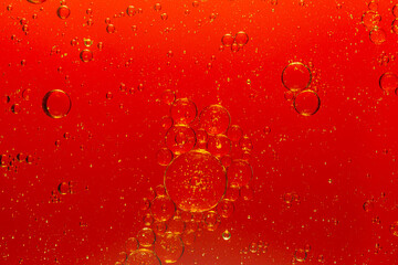 Abstract bubbles in liquid with red background. Different sized and shaped bubbles.