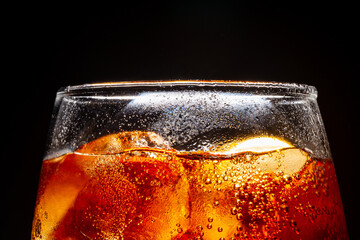 Soft drink glass with ice splash on cool smoke background. Cola glass with summer refreshment