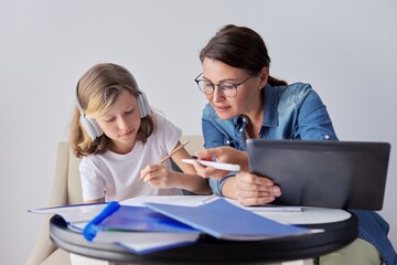 Mom and daughter student learning school lessons together at home