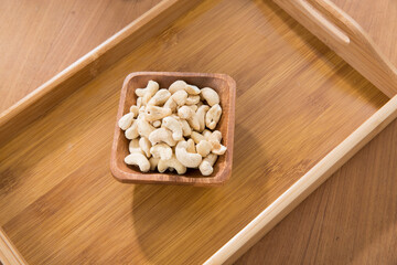 Fototapeta na wymiar Bowl of Cashew nuts on wooden tray