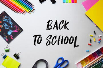 Composition with various school supplies on a gray background. Creative background, layout. Preschool education concept. Back to school lettering.