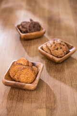 wooden tray with many different types of cookies on wooden background.