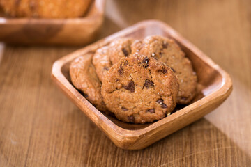 wooden tray with many different types of cookies on wooden background.