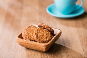Bowl of cookies with tea cup on table