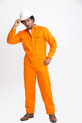 Indian municipal young worker standing with safety helmet on white background.