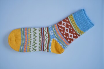 socks with a pattern on a  blue background.Winter warm knitted socks with a multicolored variegated pattern