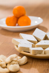 Pile of orange Indian sweets Motichoor Laddu with Kaju katli
