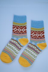 socks with a pattern on a  blue background.Winter  knitted socks with a multicolored variegated pattern
