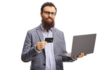 Bearded man holding a credit card and a laptop computer