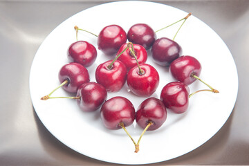 juicy cherry berries lie on a white plate. healthy food for breakfast. fruits of vegetation. fruit...