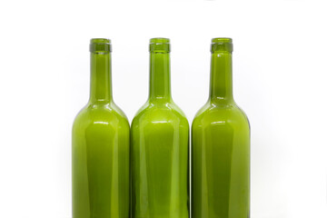 Three green empty wine bottles on a white background