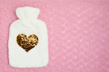 winter flat lay with hot water warmer on pink