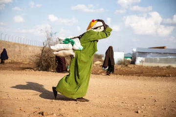 Zelfklevend Fotobehang Woman walking home after food distribution during deadly drought in Somalia © Mustafa Olgun