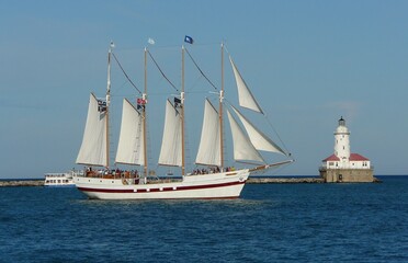 Fototapeta na wymiar Sailboat near the lighthouse at the Navy pier in Chicago; Lake Michigan