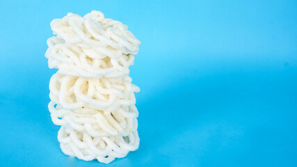 Traditional Crackers White Kerupuk from Indonesia isolated on blue background