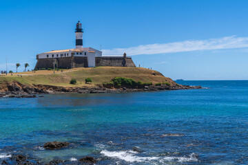 The historic architecture of Salvador in Bahia, Brazil showcasing the Farol da Barra Lighthouse at Bahia de Todos os Santos Bay on a sunny summer day