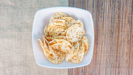 fried tempe chips or keripik tempe served on bowl. made from flour and fried until crispy. Delicious, crunchy, tasty and savory. with selective focus