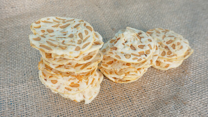 Stack of irregular shape crunchy keripik tempe or traditional tempeh chips. On of popular Indonesian snack