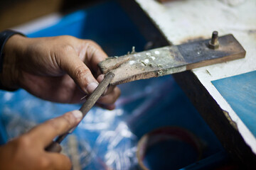 Working desk for craft jewelery making with professional tools. Silver production. Master's hands