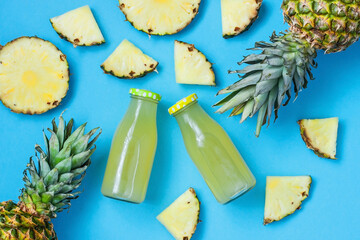 Tropical composition with pineapple and juice in bottle, flat lay