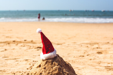 Fototapeta na wymiar Christmas cap on the background of the sea