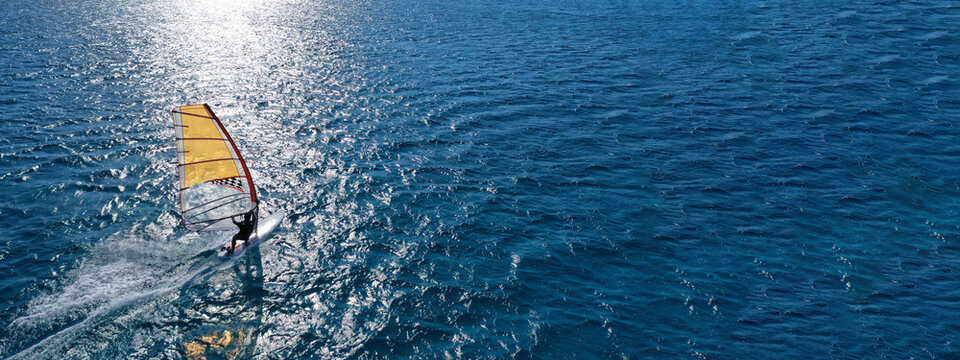 Aerial drone ultra wide photo of professional wind surfer practice in deep blue open ocean sea