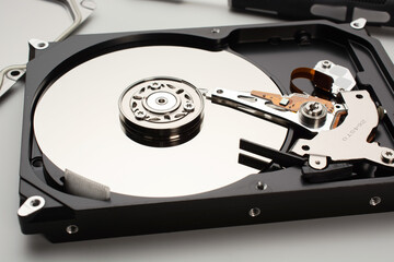 computer hard disk inside view with mirrored blank disks on which data is recorded and a magnetic...