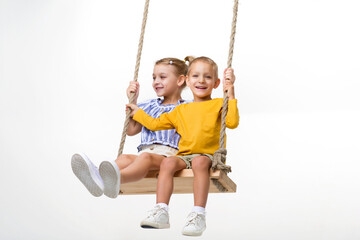 Happy kids swinging on rope swing