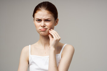 woman touching face with hand toothache gray background emotions