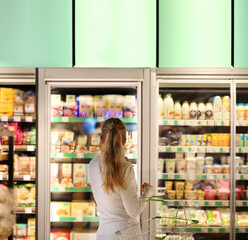 Woman choosing a dairy products at supermarket.
