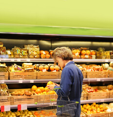 Young man buying vegetables and fruits at the market..
