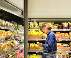 Young man buying vegetables and fruits at the market..