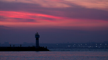 A landscape photo of Istanbul view at sunset with silhouette lighthouse and sea