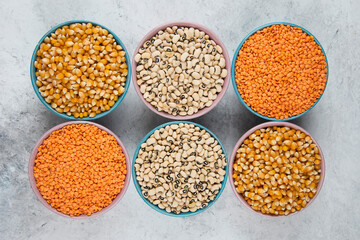 Assortment of various raw beans and corns on marble surface