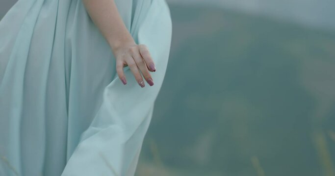 Close up shot of light dress being blown by wind. Girl standing on top of a mountain - tranqulity, freedom concept 4k footage