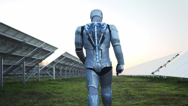Back view of the innovative cybernetic prototype droid examining power generation sustainable energy production at ecological solar field station. Artificial intelligence, humanoid robot concept
